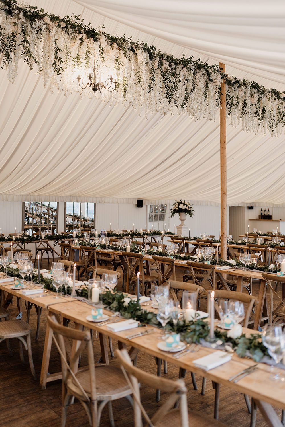 Middleton Lodge estate styled with long trestle tables with green florals and candles ready to welcome evening guests.