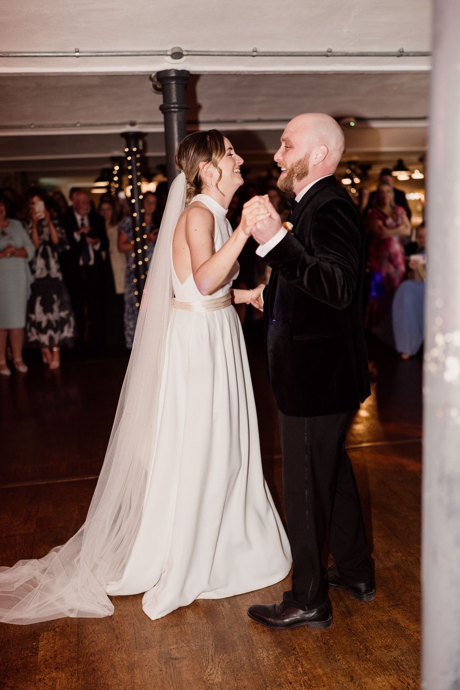 Couple sharing intimate dance moment at indoor wedding reception.