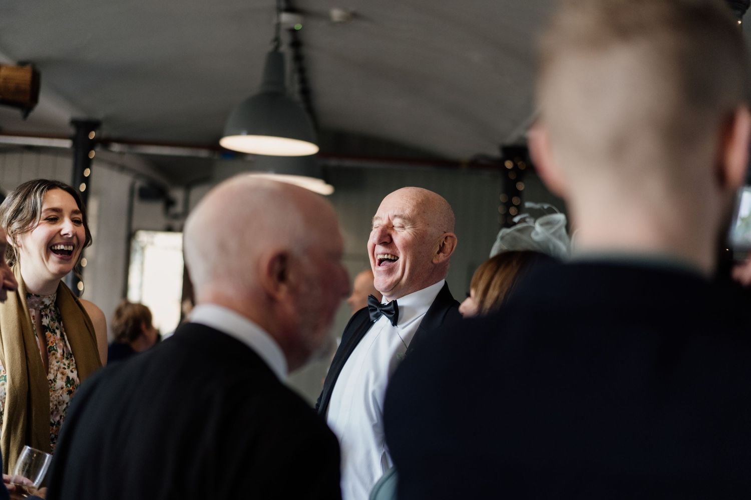 Guests sharing laughter and conversation at an elegant indoor reception event.