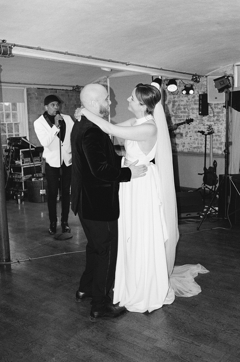 Bride and groom dancing and smiling during their first dance.