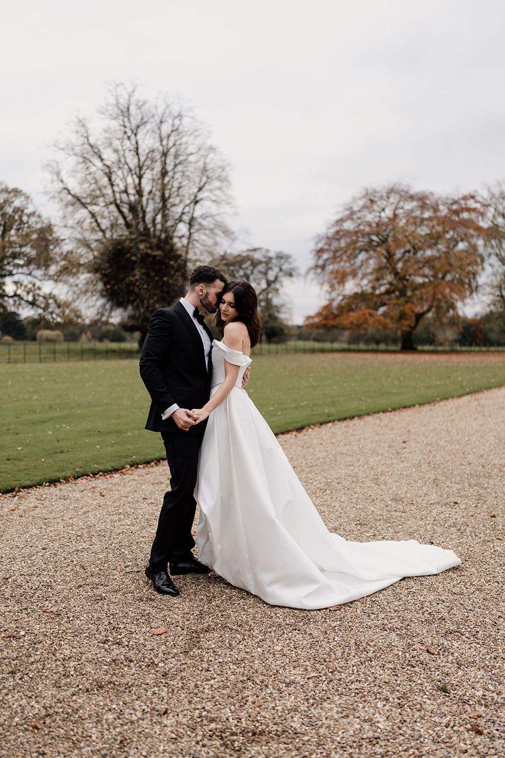 Bride and groom holding hands, smiling, laughing while working through the grounds of Rise Hall.