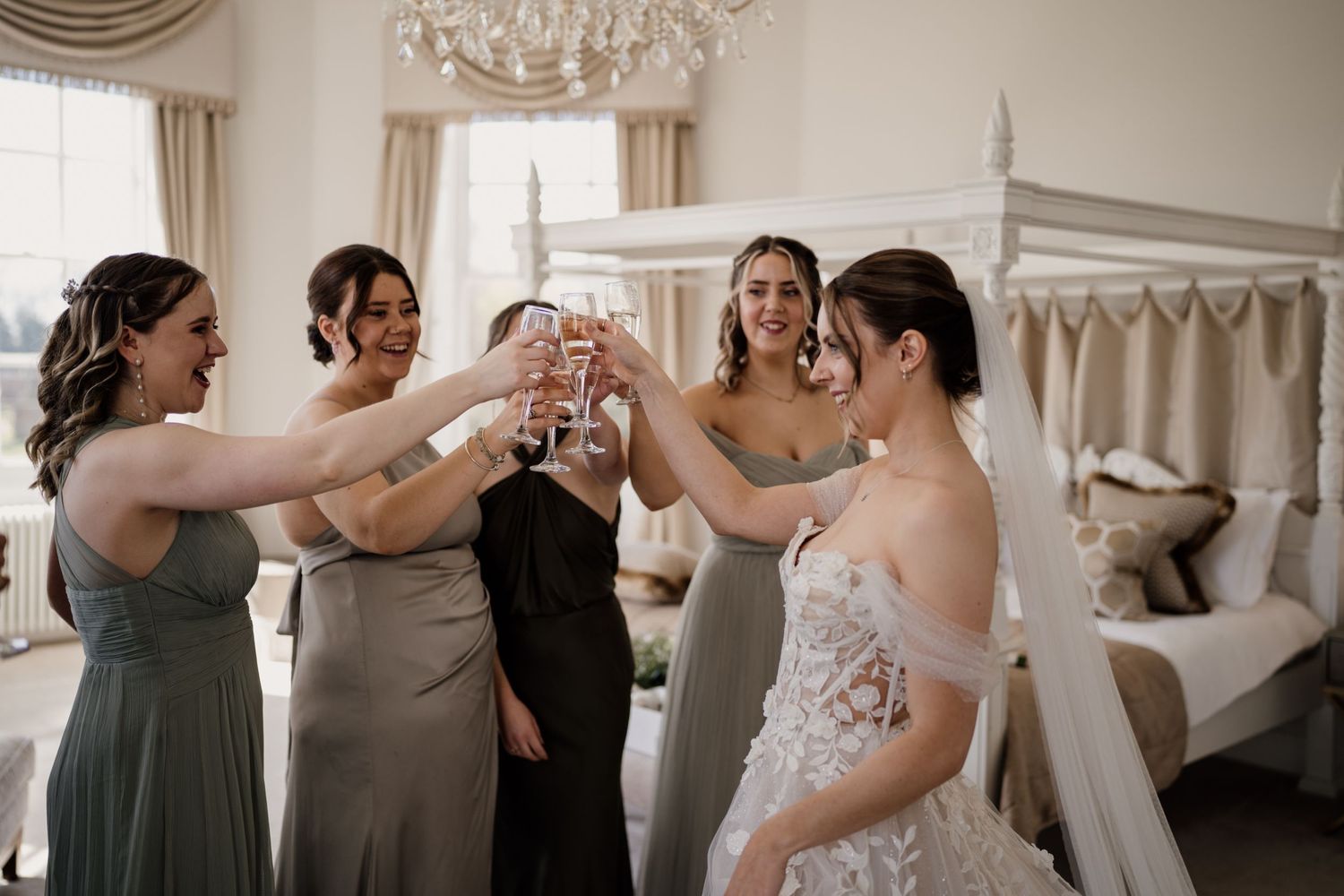 bride and bridesmaids doing a cheers while stood in a cricle.