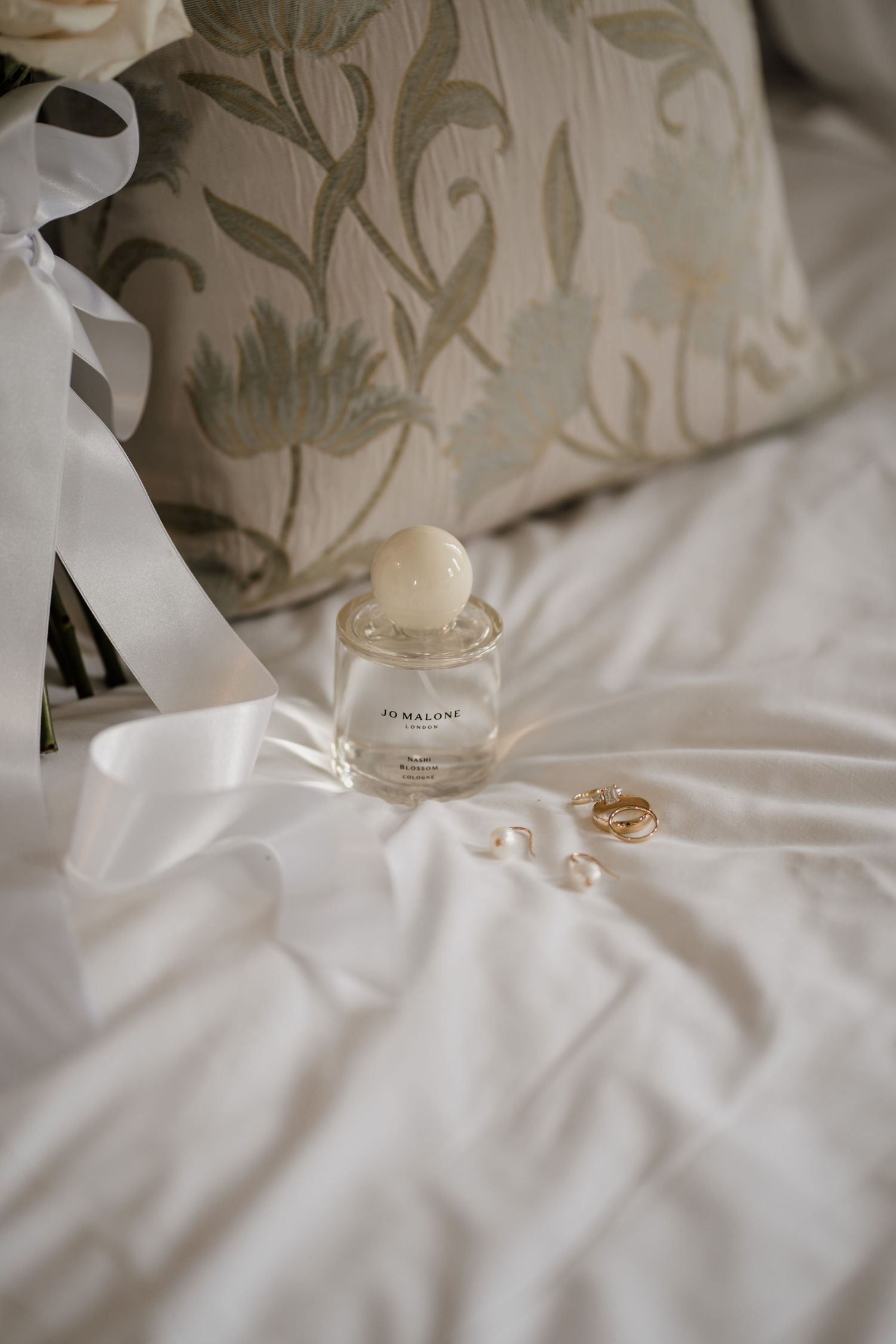 Wedding day perfume on white bedding at Middleton Lodge.