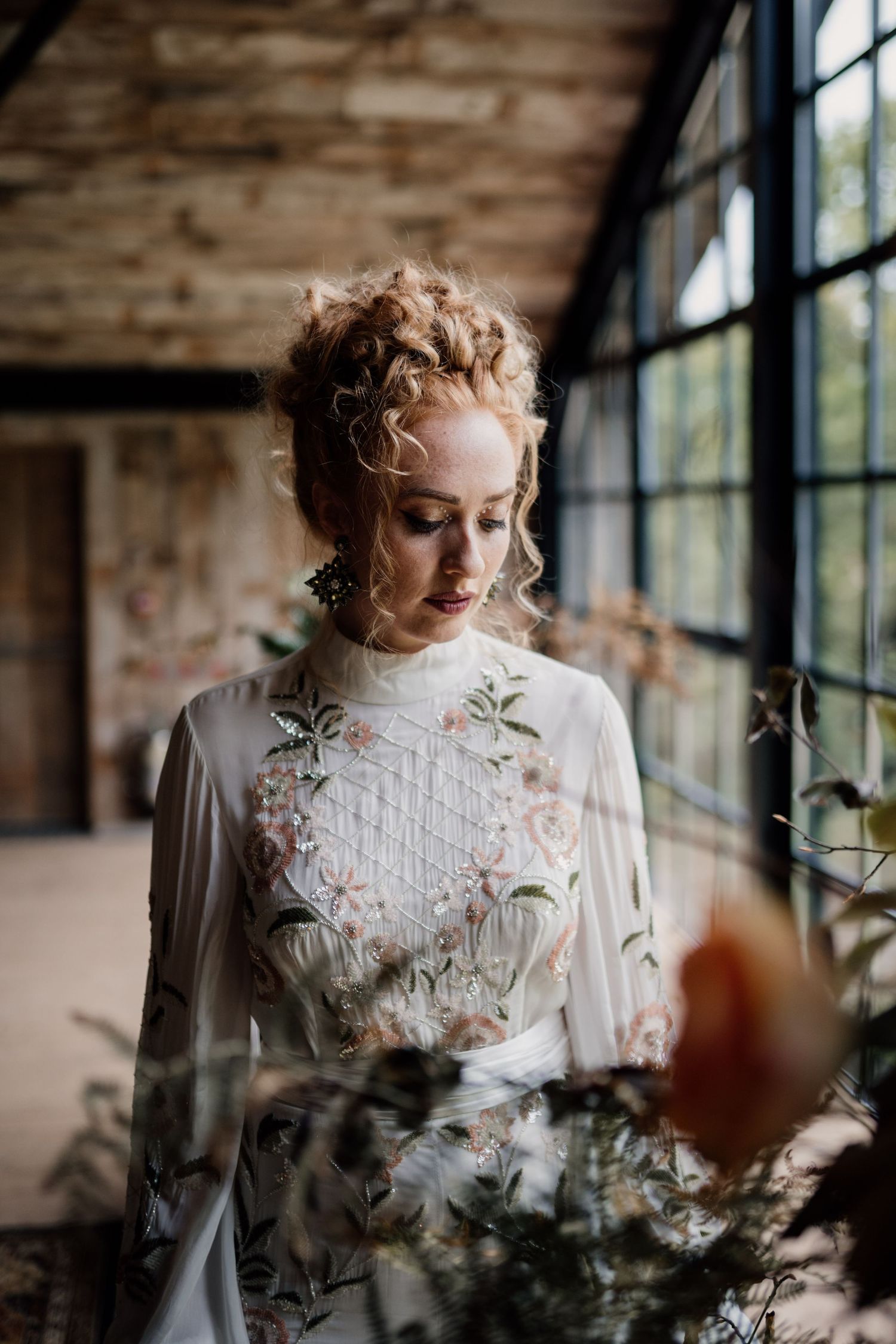 Bride holding wedding flowers wearing embroidered wedding dress.