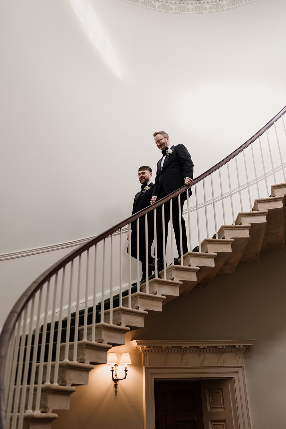 Grooms walk down the statement staircase in Middleton Lodge's main house to their intimate wedding ceremony.