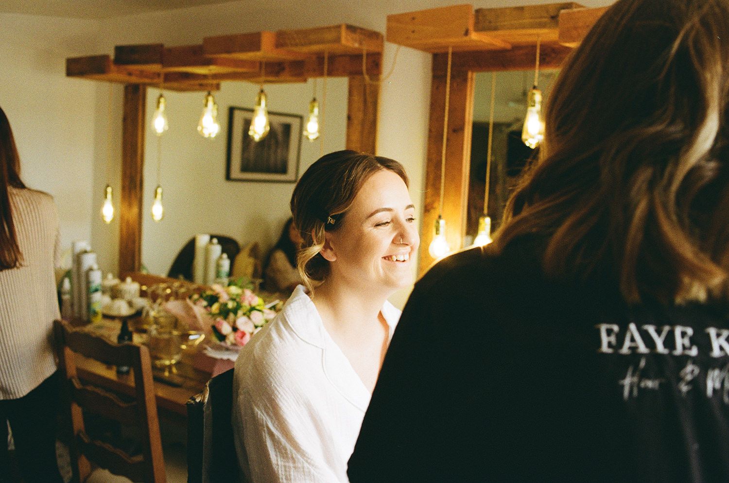 Bride laughing as she gets her makeup done at The West Mill.