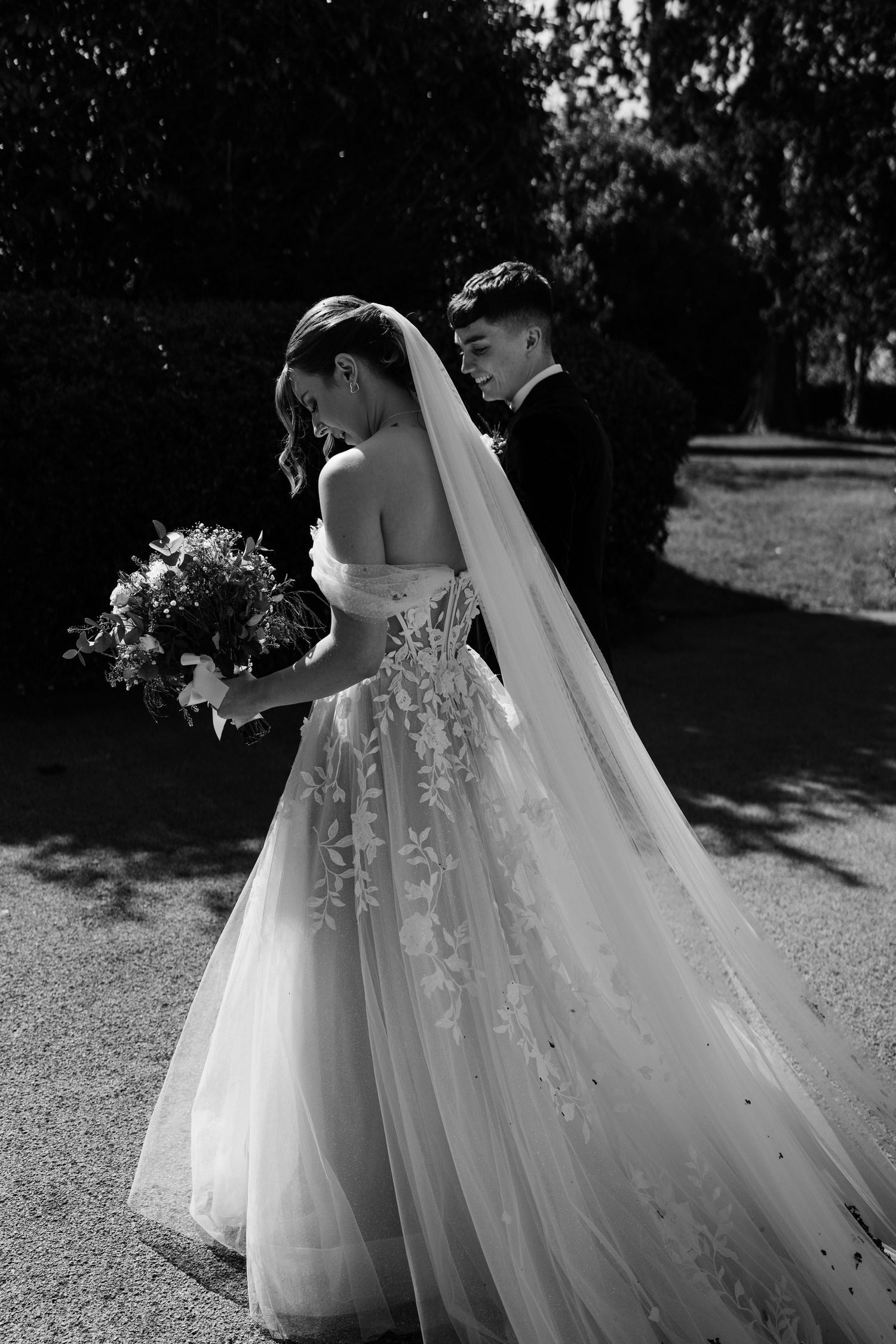 Detail of the brides dress as she walks through a courtyard.