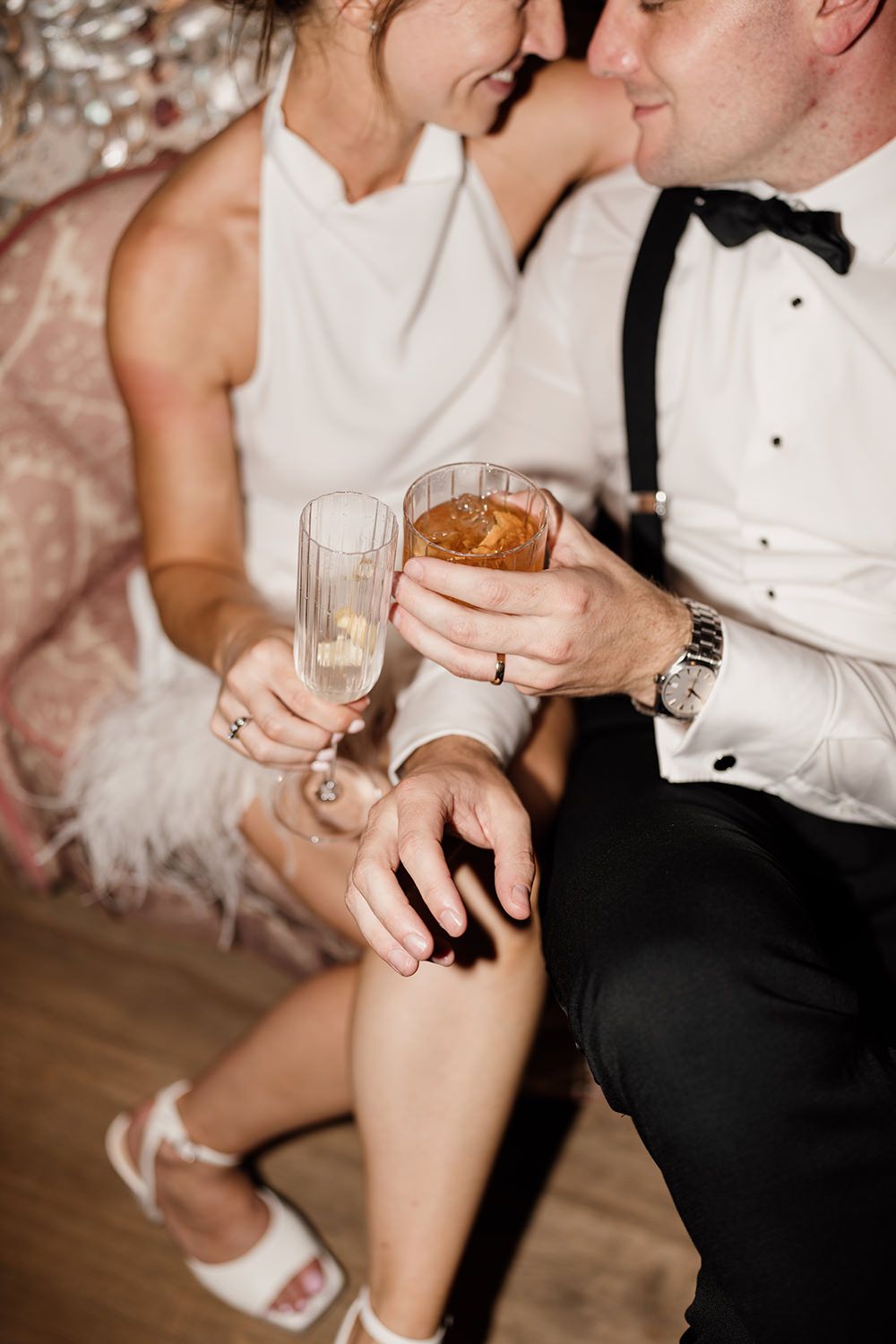 Editorial close up photograph of bride and groom toasting.