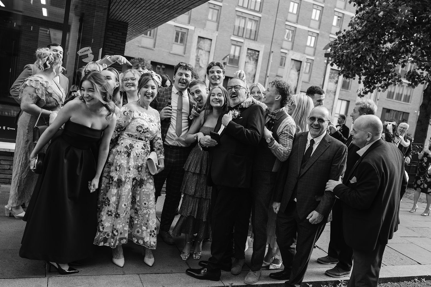 A group of people dance and socialize at a formal event in black and white vintage photograph.