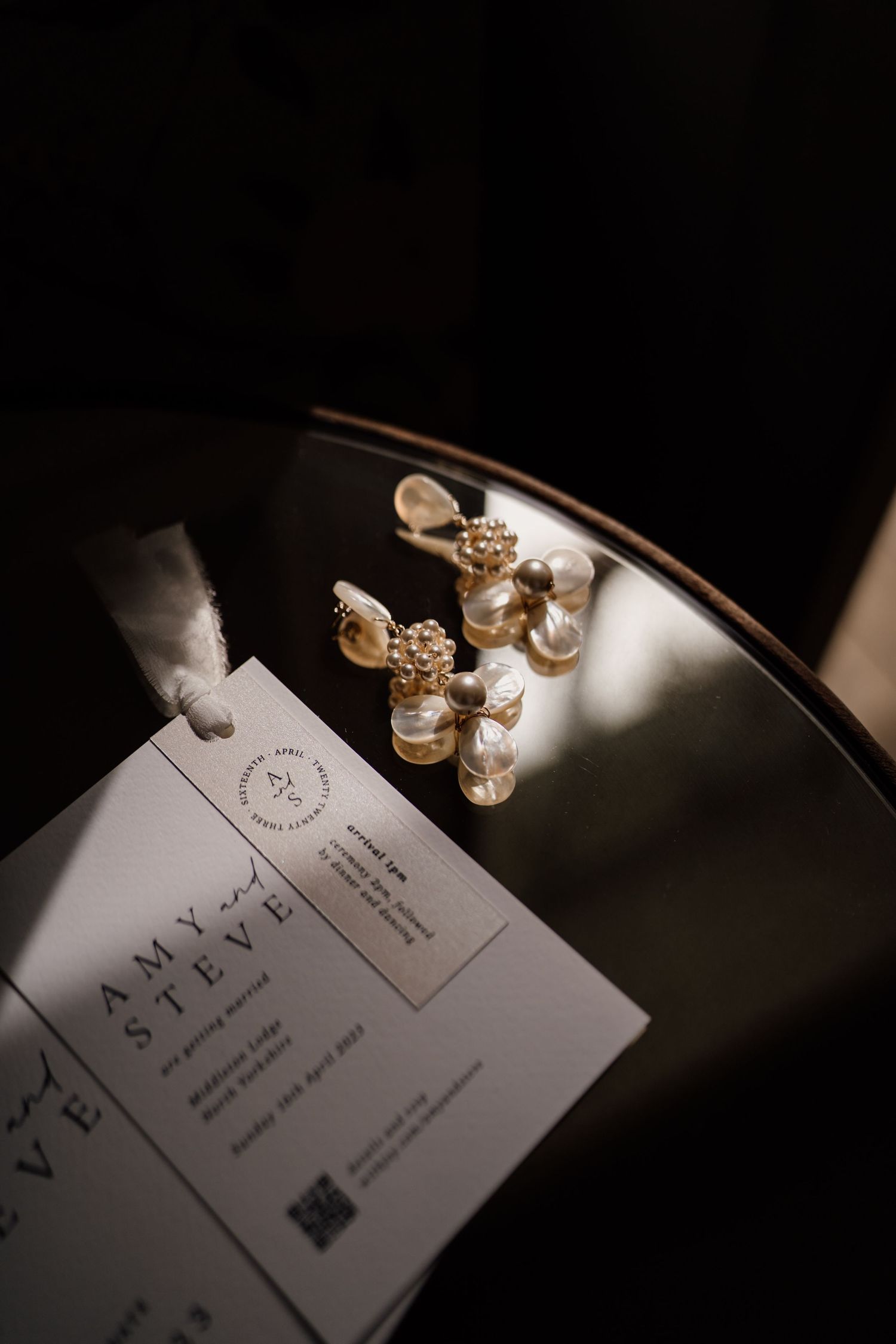 Bridal earrings on a table with the sun shining at Middleton Lodge.
