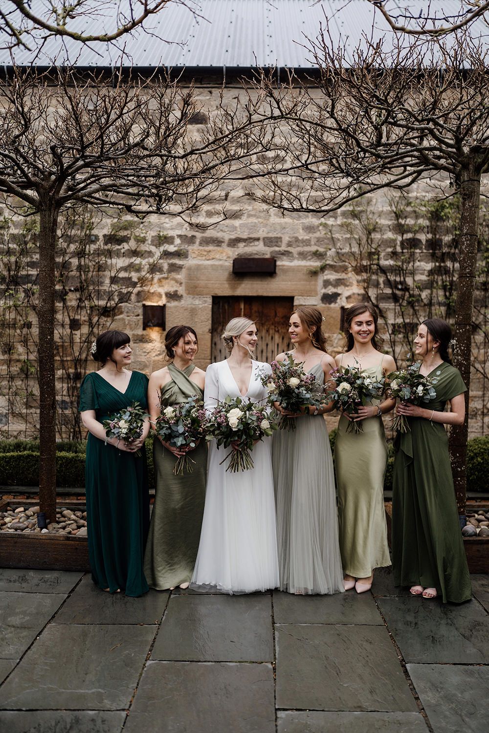 Bride and bridesmaids at Healey Barn, bridesmaids are wearing green dresses.