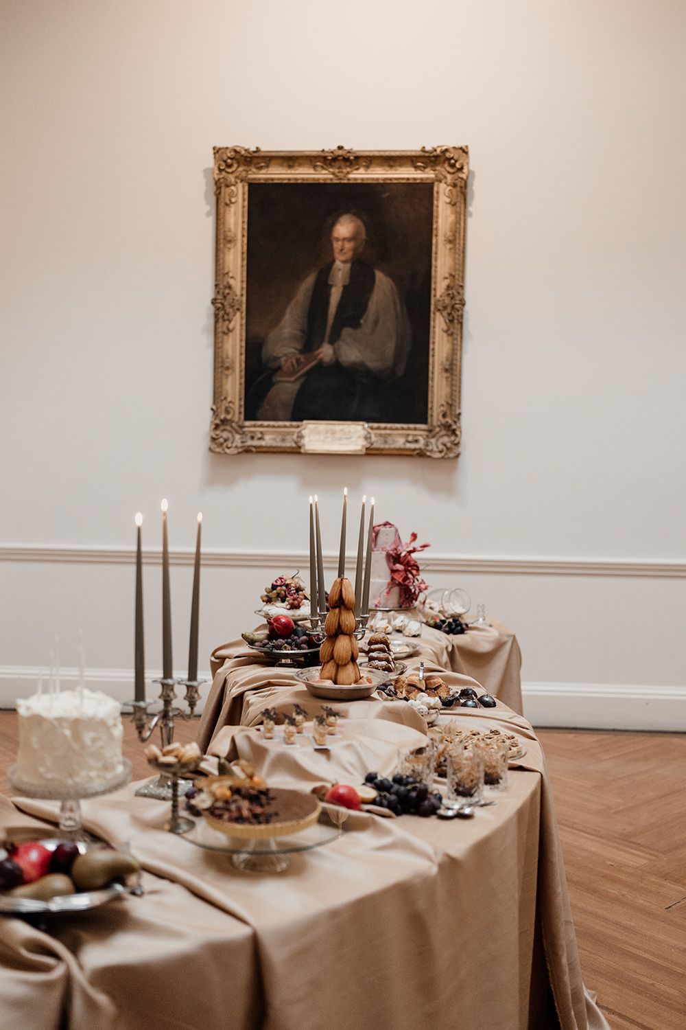 Extravagant dessert table filled with cakes, pastries and candles in the dining room at Rise Hall.