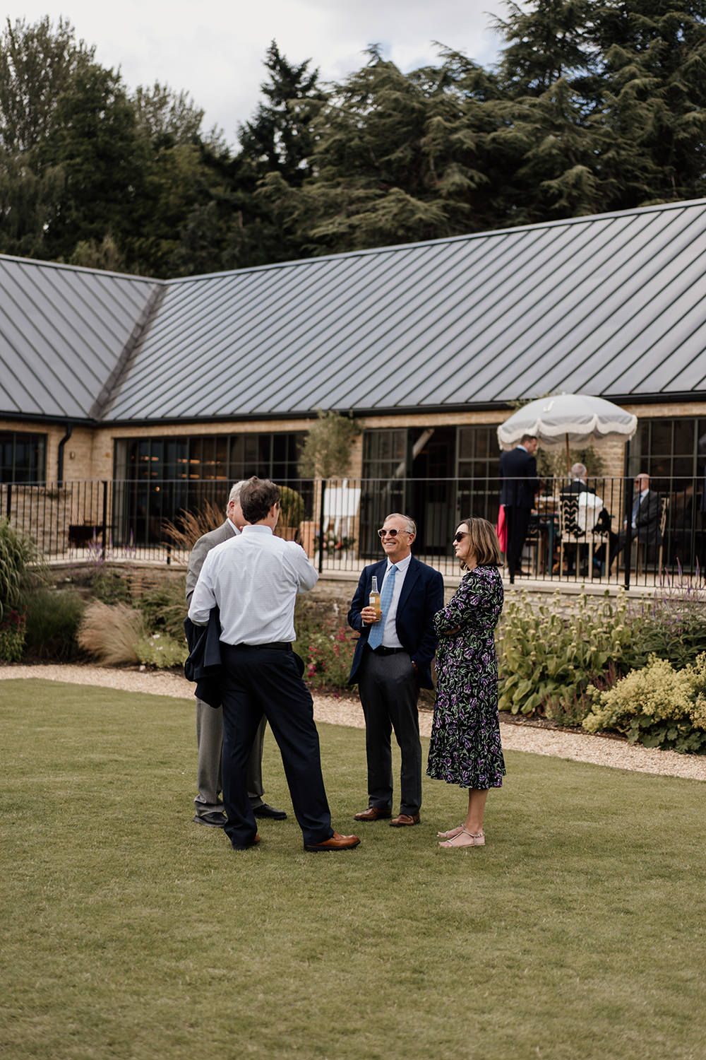 Candid wedding photography: guests enjoying cocktails on the lawn at Kin House.