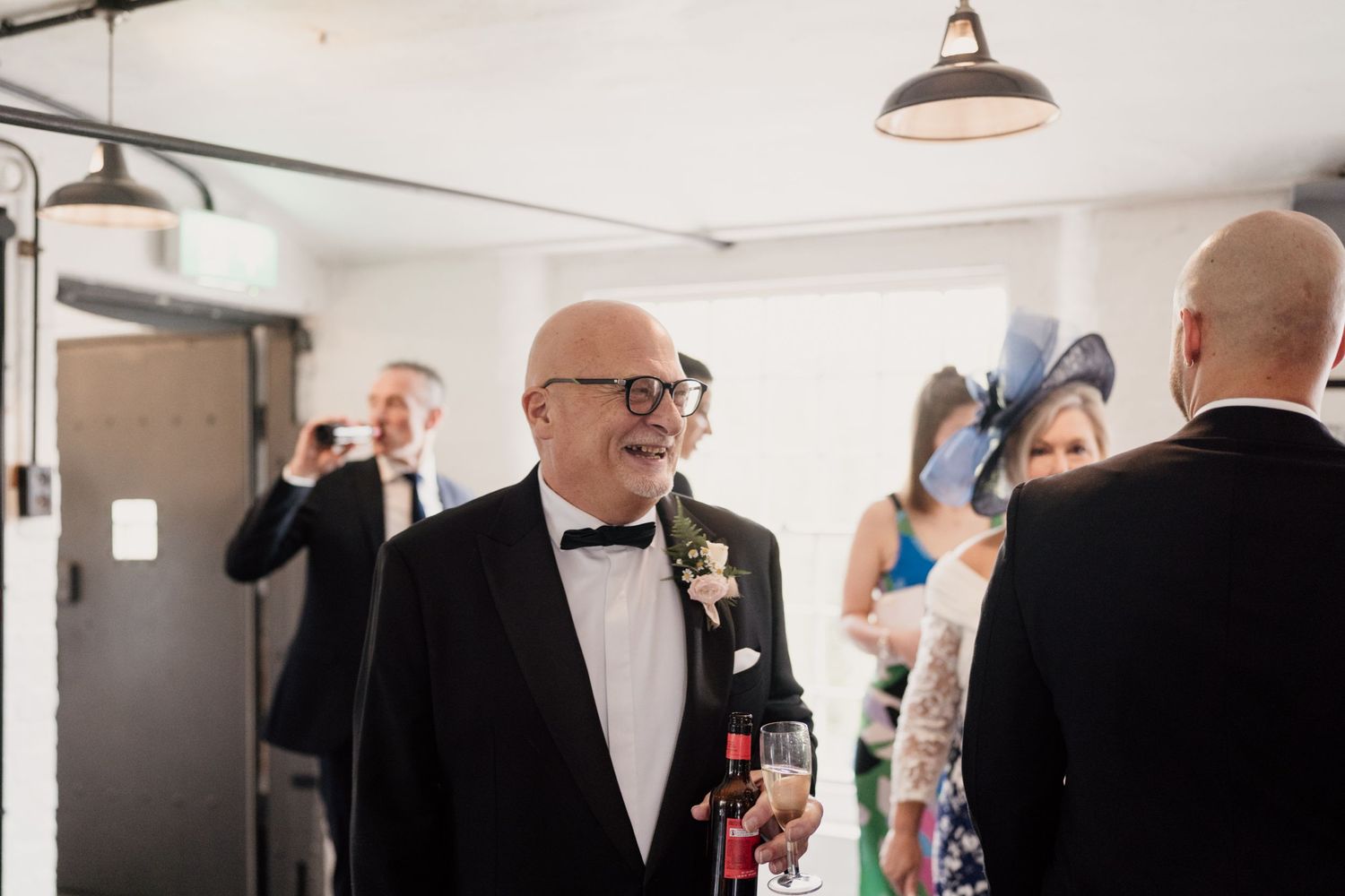 Formal gathering with guests in black tie attire at an indoor event.