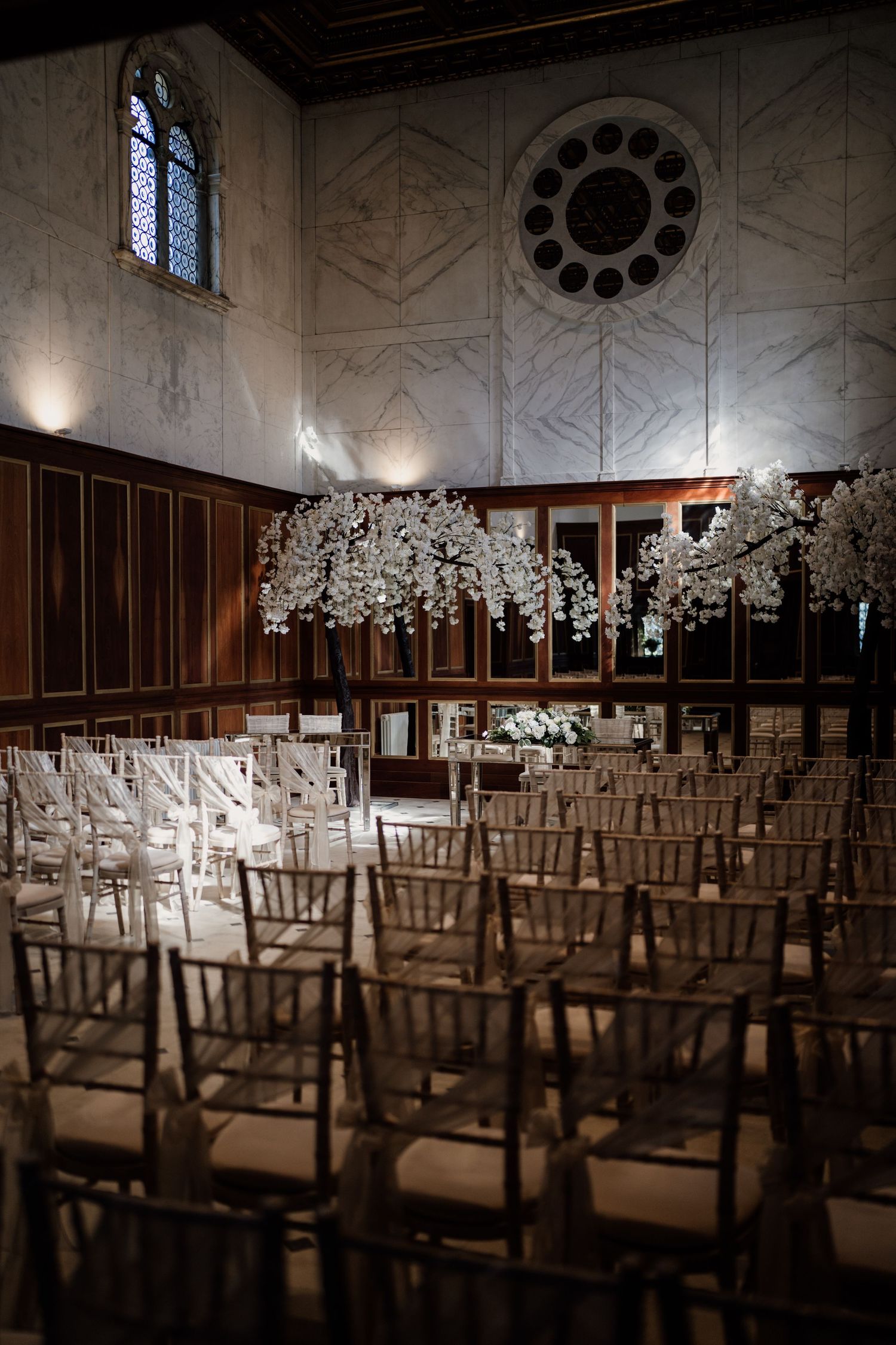 Ceremony room at Boughton Hall with sun through the window styled with white trees.
