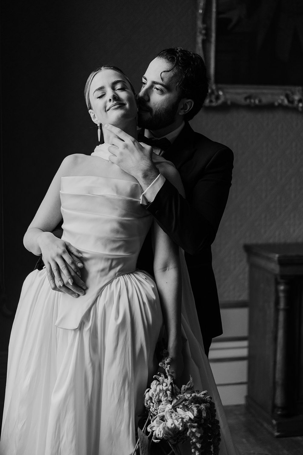 Editorial wedding portrait session: Bride and groom holding hands while looking towards each other.