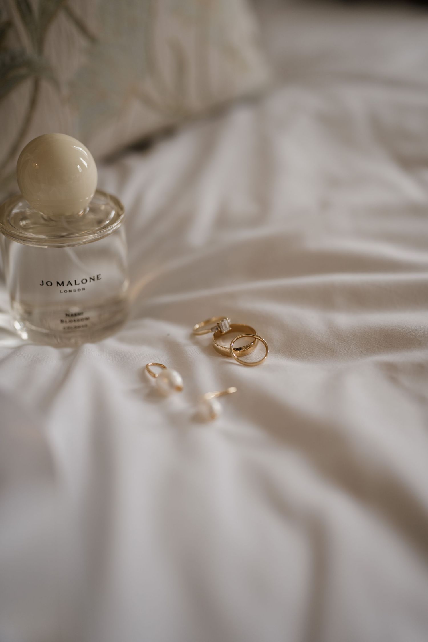 Bridal jewellery on white bedding at Middleton Lodge Estate.