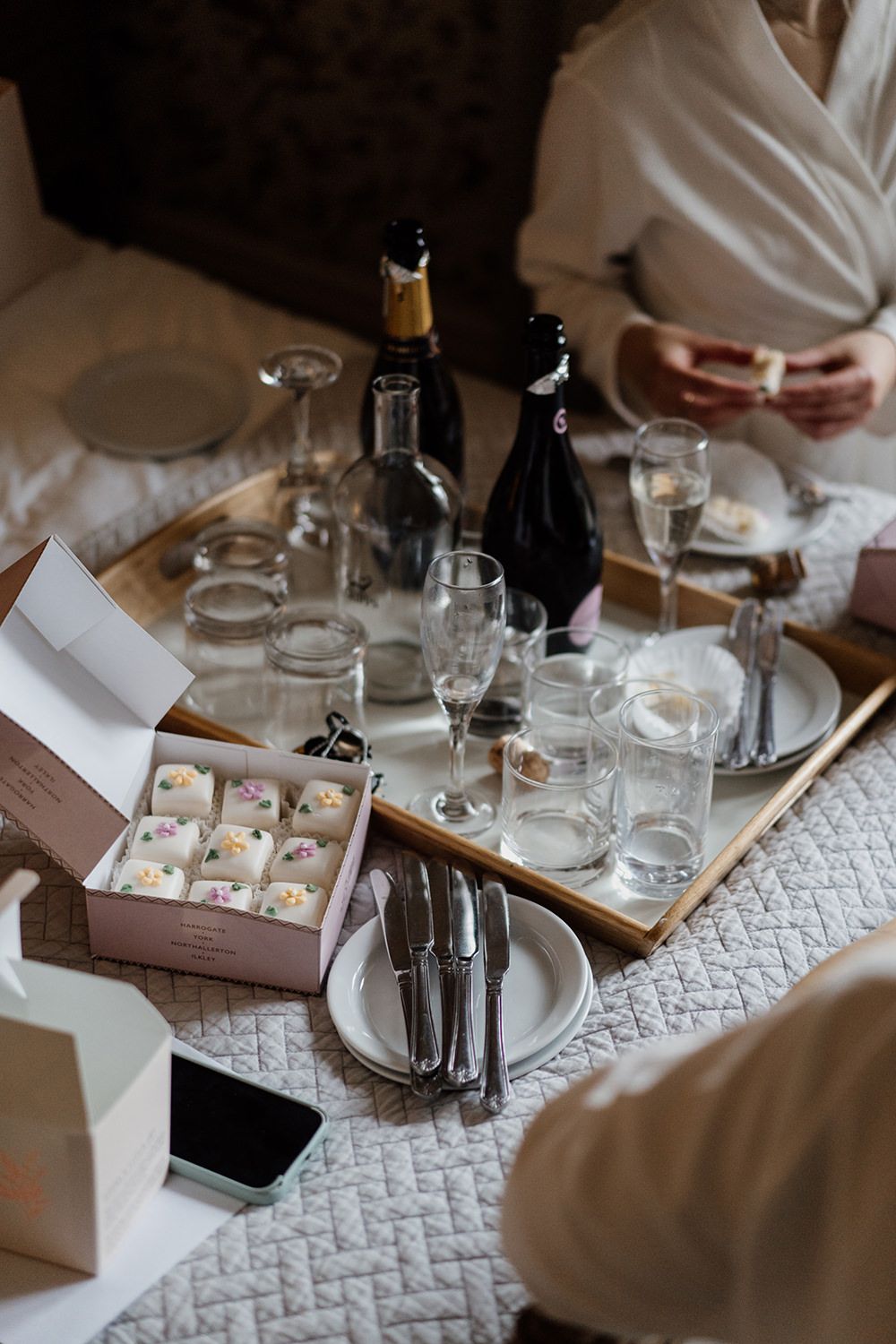 Food tray filled with glasses, cups and french fancies from Bettys tearoom.