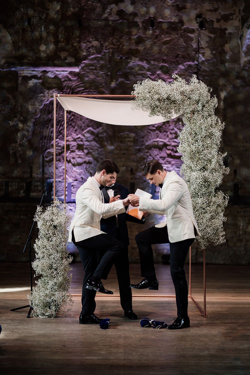 Two grooms breaking the glass on their wedding ceremony.