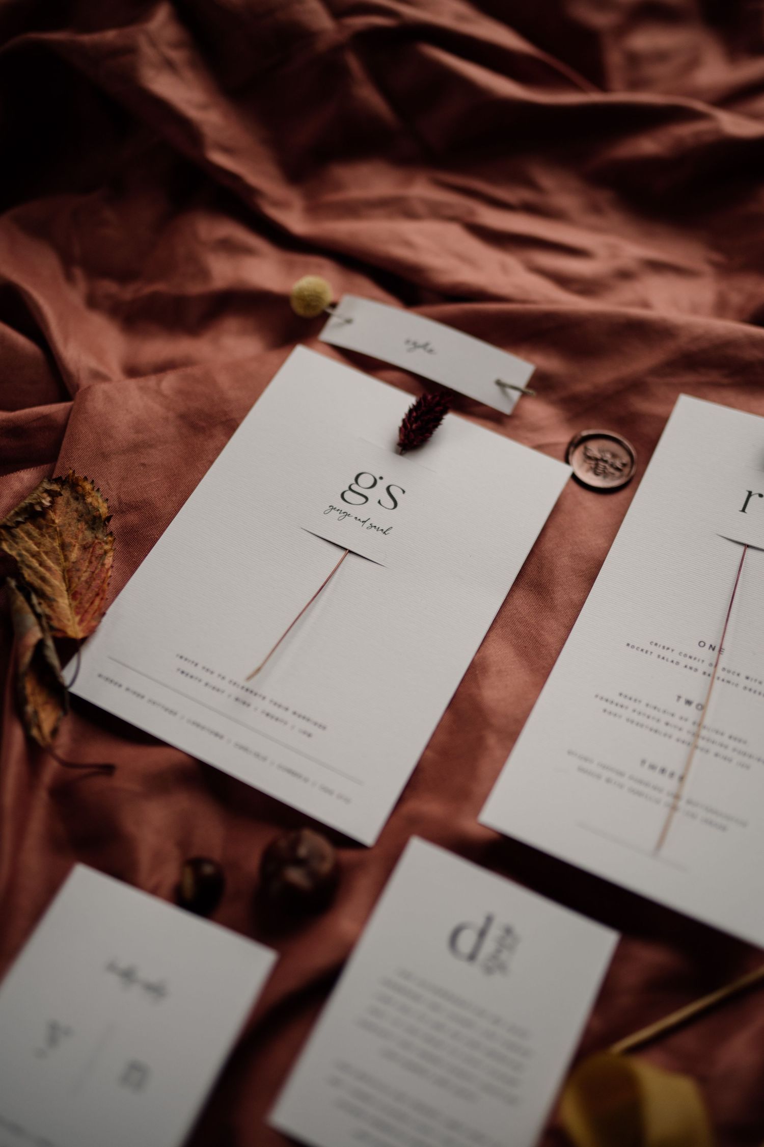 Timeless wedding stationery styled on a rust fabric.