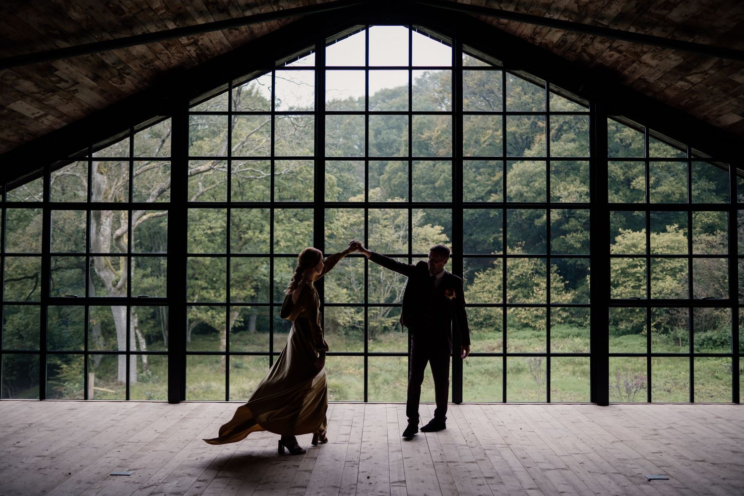 Couple dancing at Hidden River Barn with the windows silhouetting them.