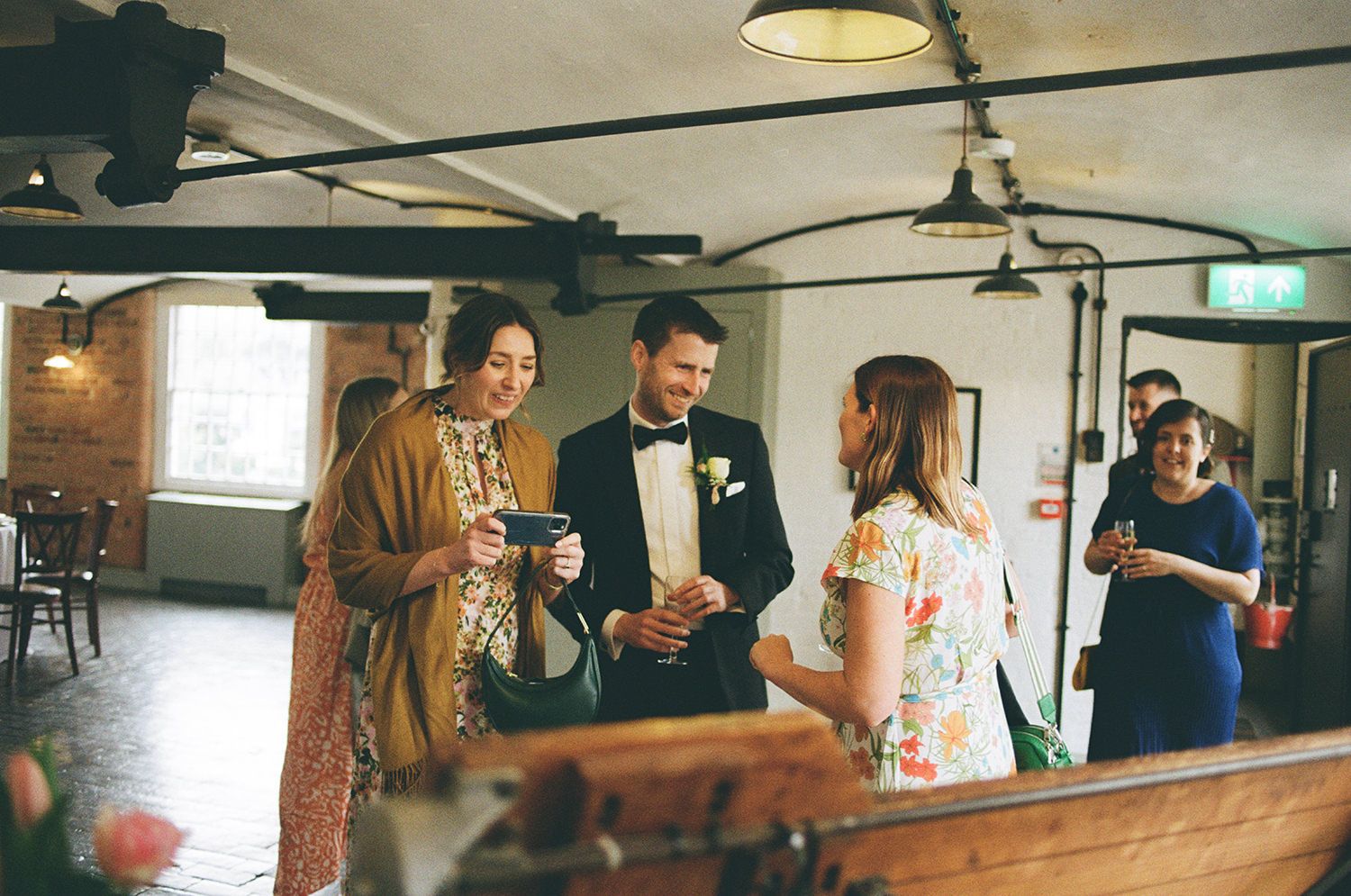 Wedding guests smiling and laughing while looking for their wedding table.