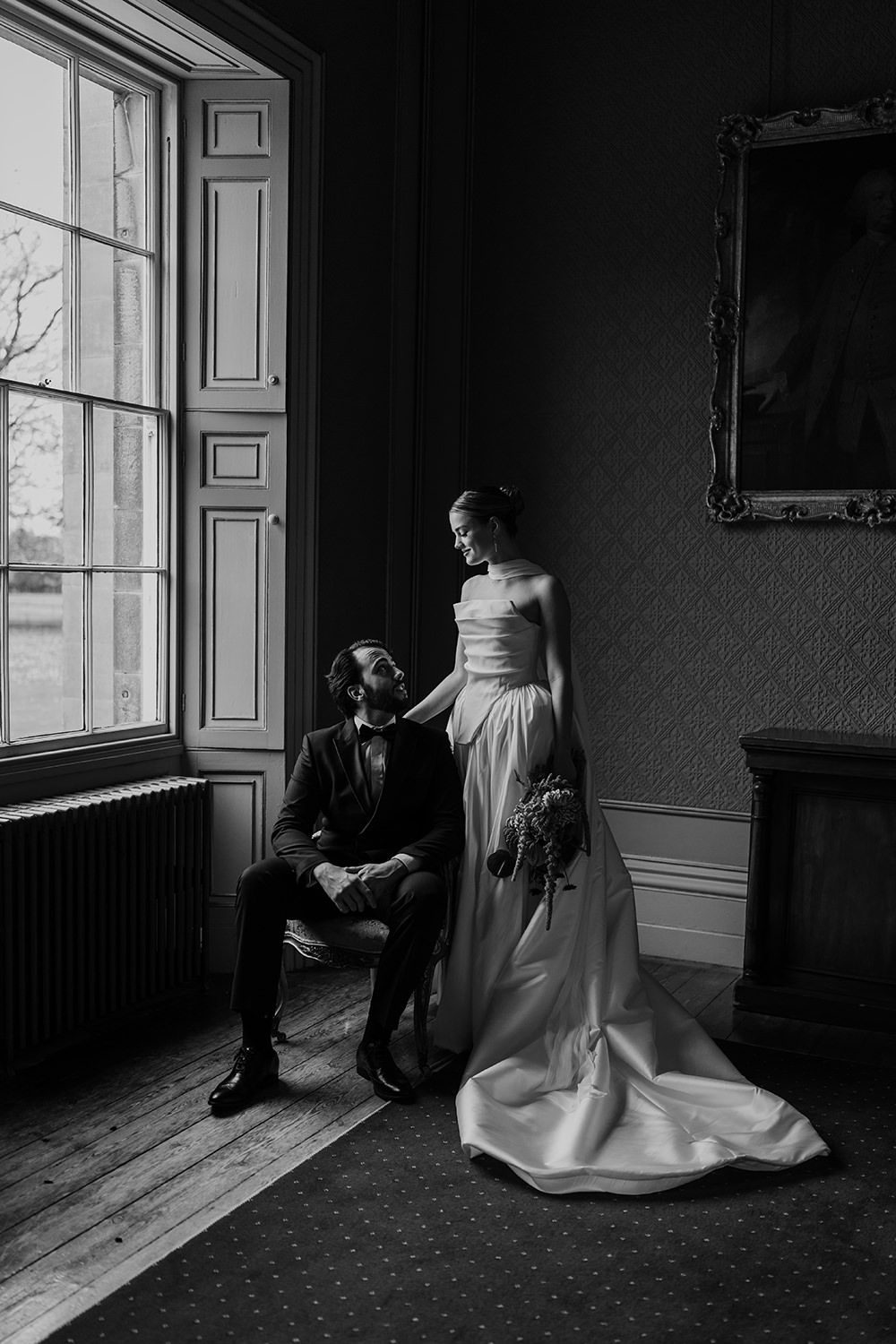 Editorial wedding portrait session: Bride and groom holding hands while looking towards each other.