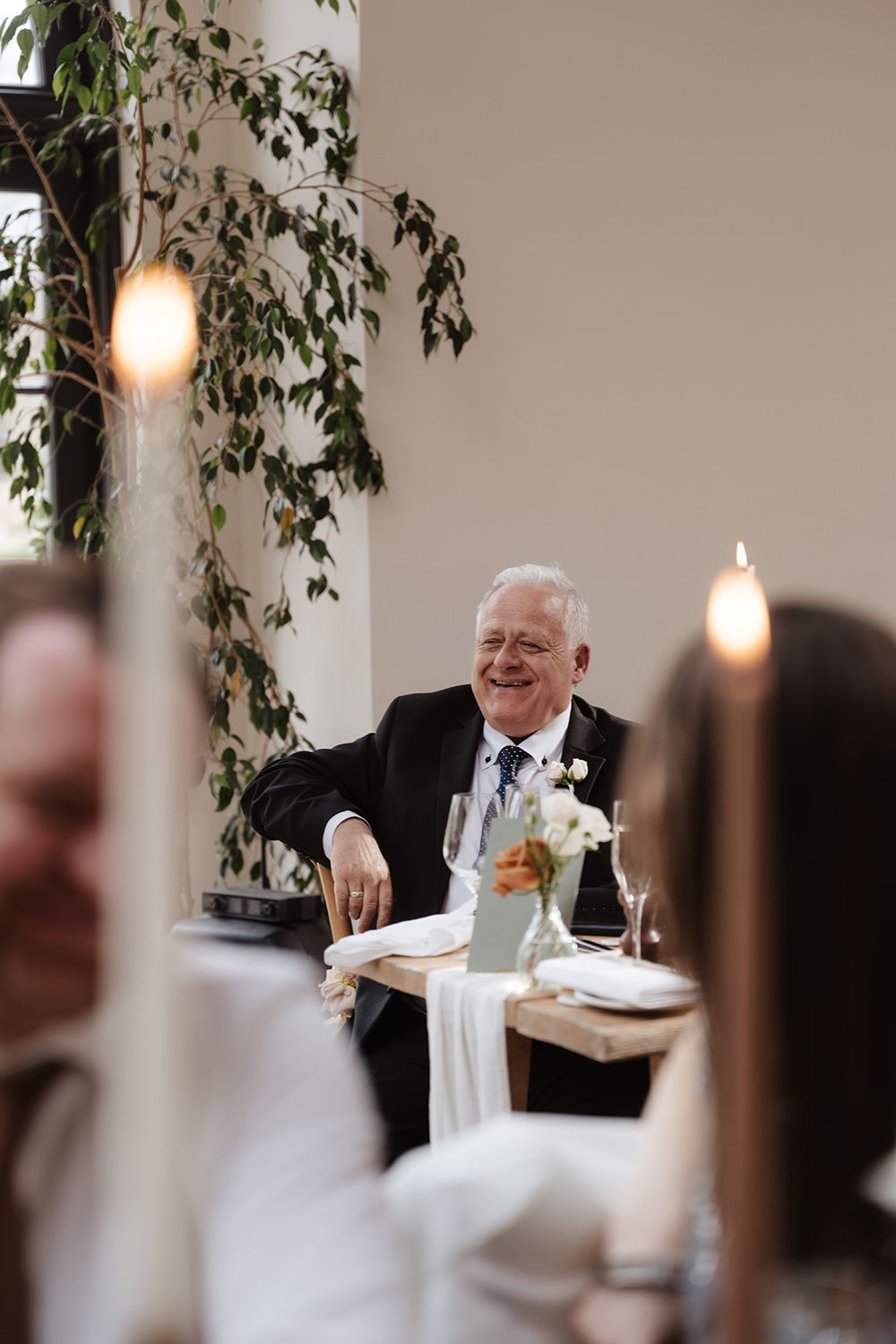 A guest enjoying a meal at an elegant wedding reception with decorative vines and warm lighting.