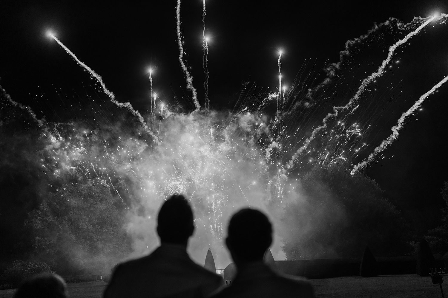 Grooms and guests watch firework display on their wedding evening at luxury UK wedding venue Middleton Lodge.