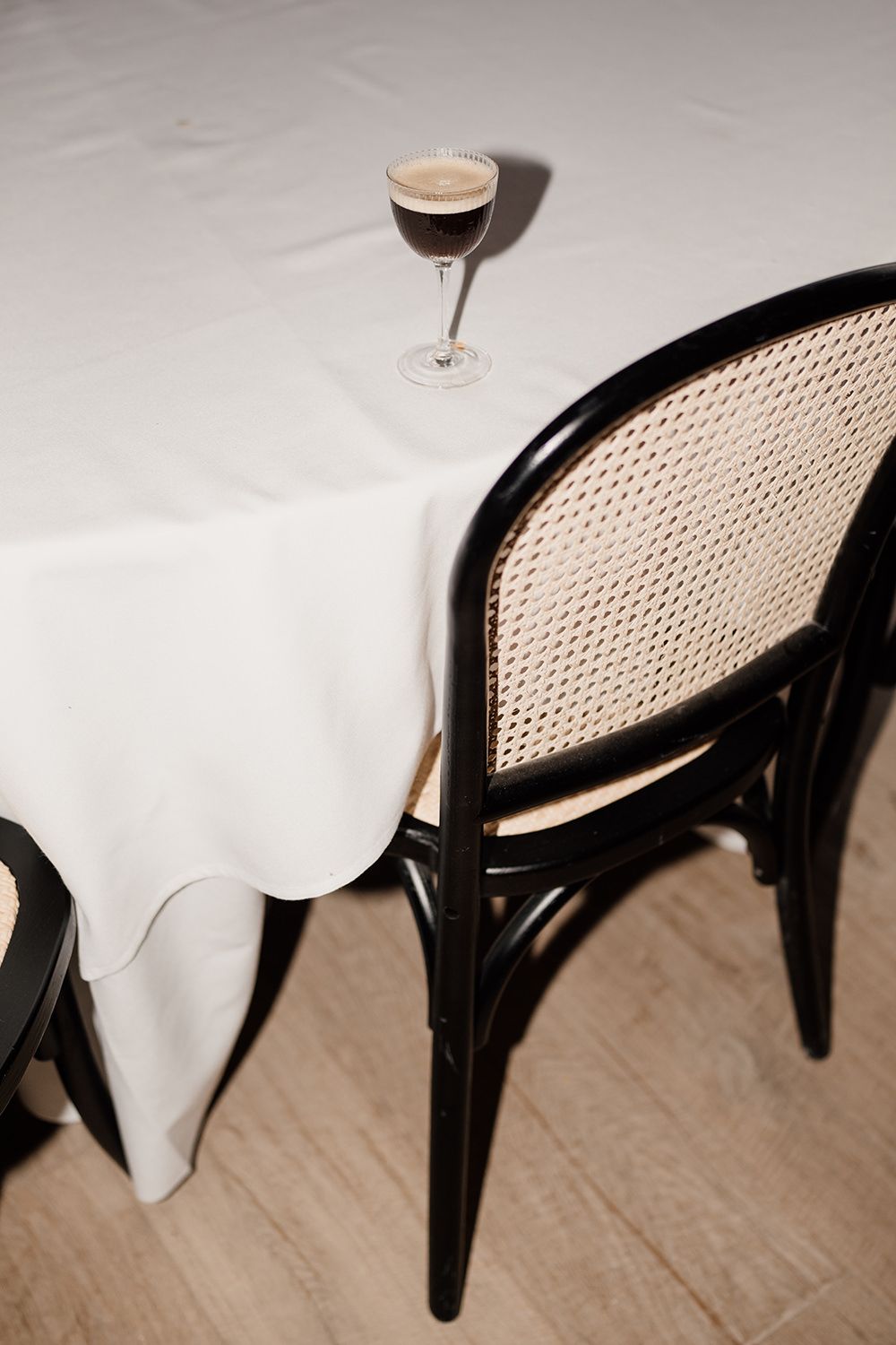 Espresso martini glass on a white table with editorial style photography.