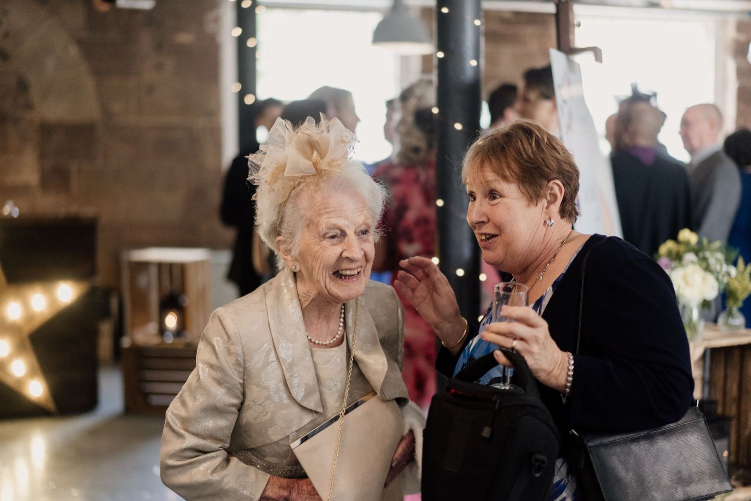 Two wedding guests sharing a joyful moment at the reception.