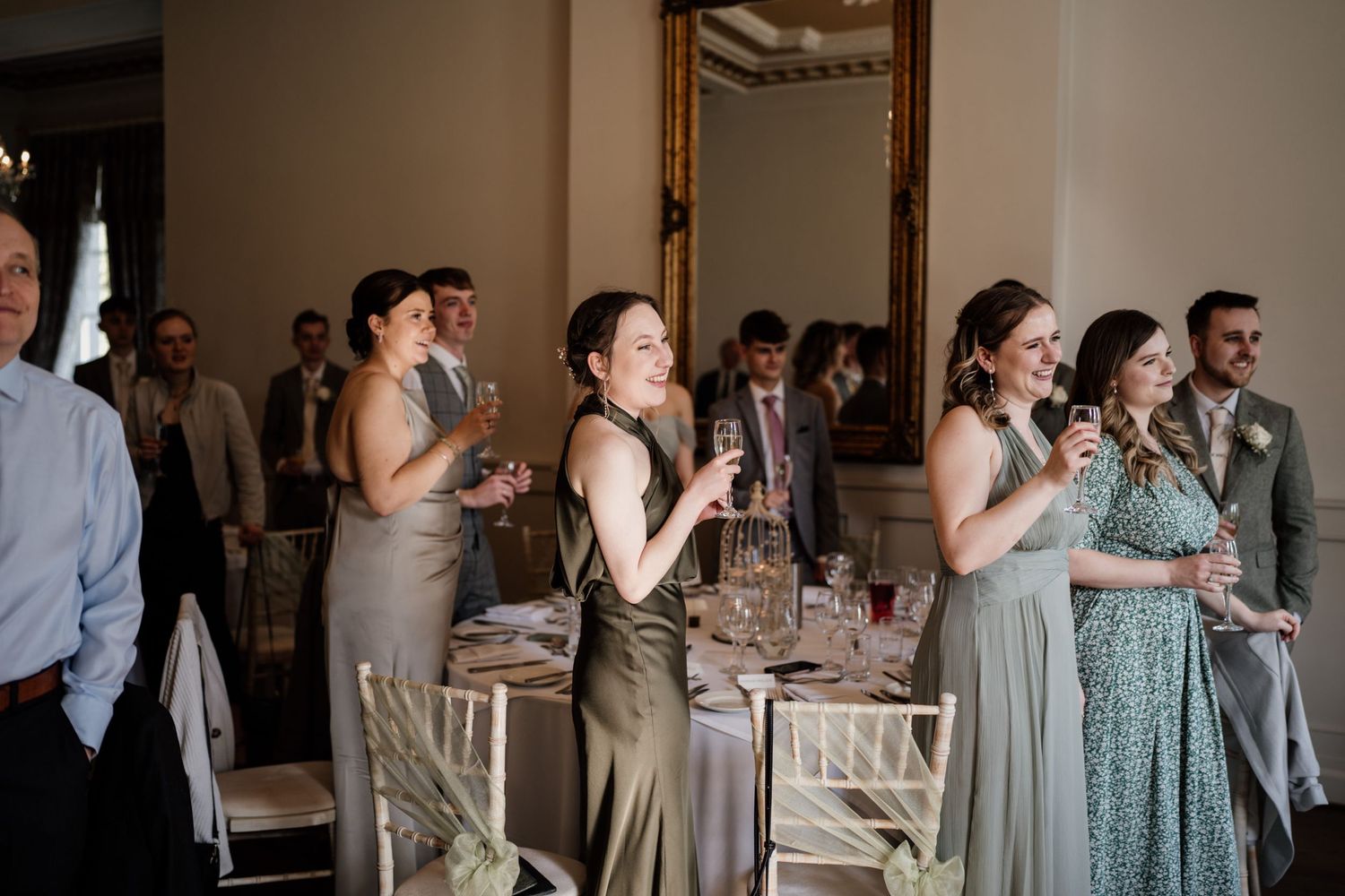 Wedding guests standing by their table clapping the speeches.