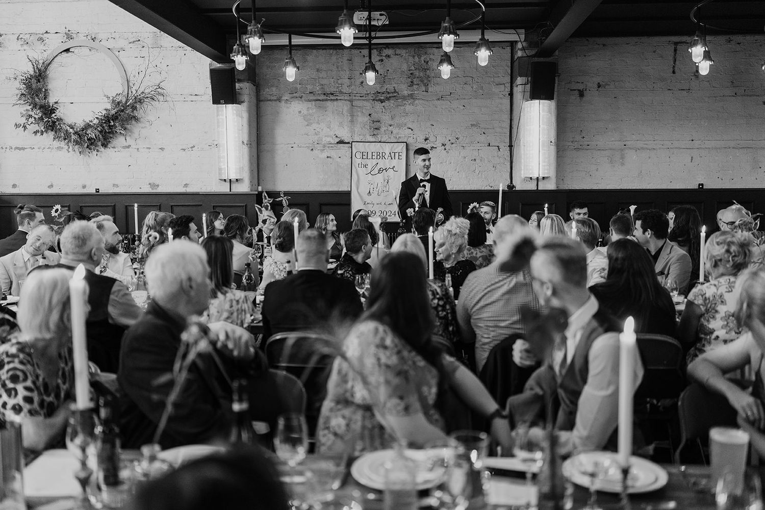 People dancing and celebrating with friends at a wedding reception under string lights and decorations.