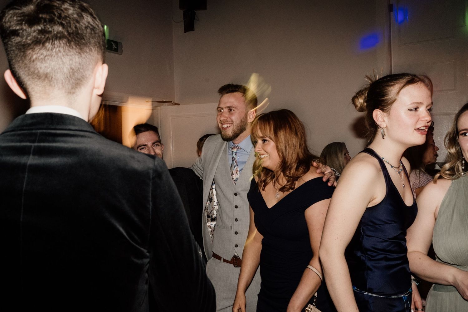 Bridesmaid dancing with friends at wedding party at Bourton Hall.