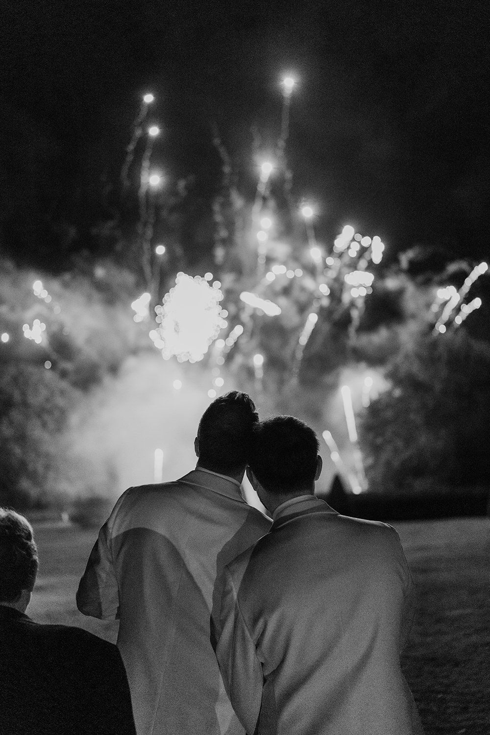 Grooms and guests watch firework display on their wedding evening at luxury UK wedding venue Middleton Lodge.