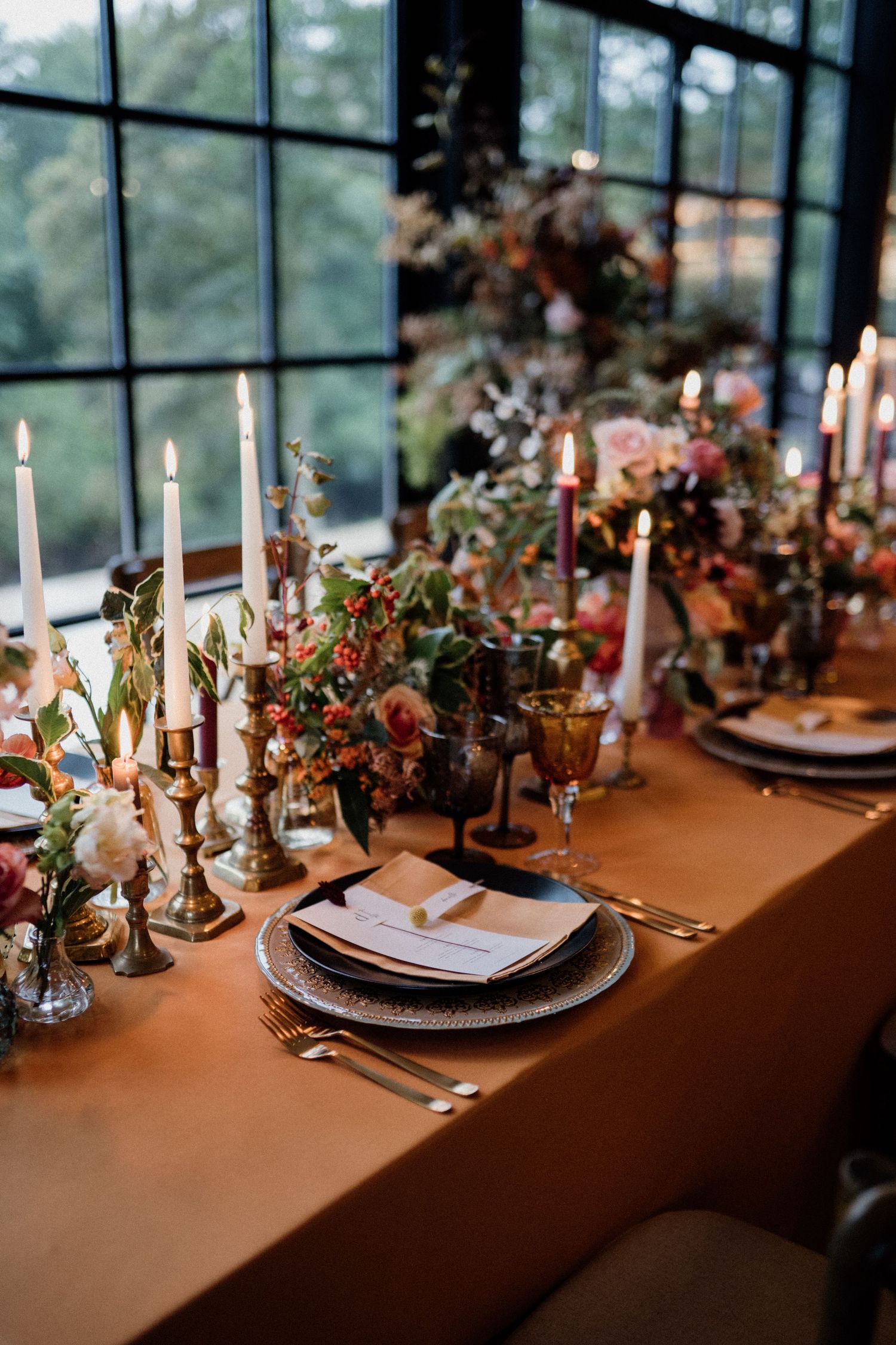 Wedding table styled in autumnal colours, fabrics and rust coloured florals.