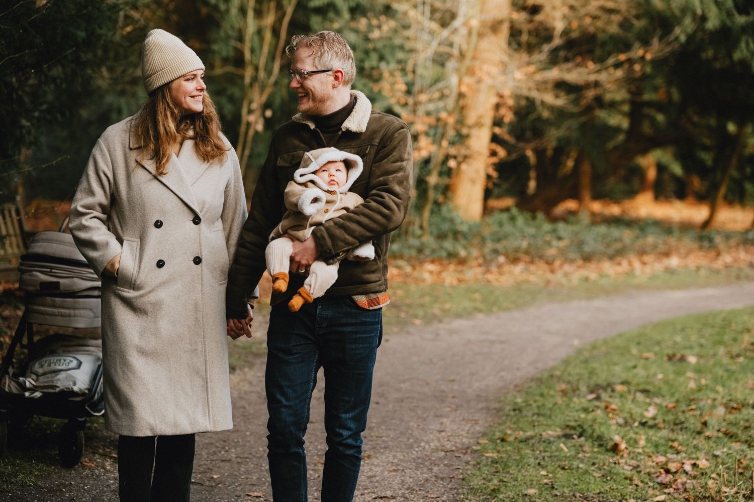 Documentaire gezinsfotografie in de natuur: ouders wandelen met baby door winters bos in regio Leiden.