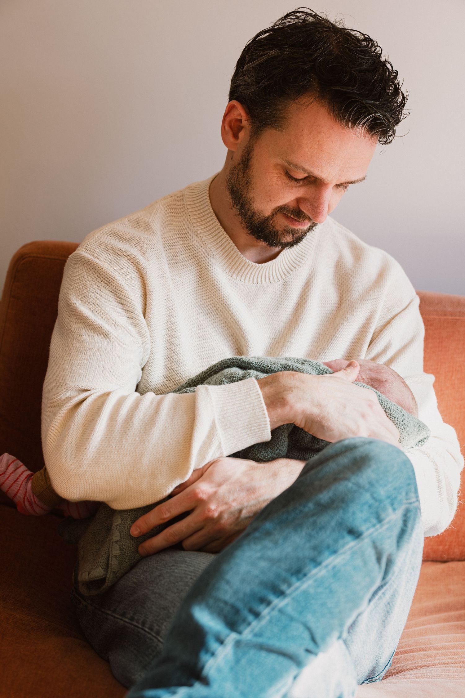 Papa houdt pasgeboren baby vast tijdens kraamtijd, kraamvisite regels Mama Nora Fotografie