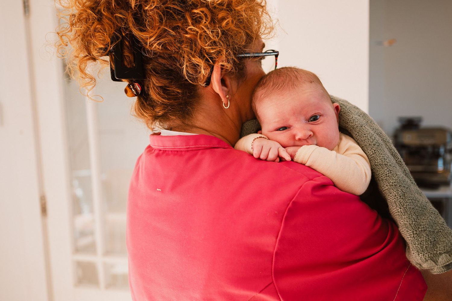 Baby op de arm bij de kraamzorg, kraamtijdfotograaf Leiden