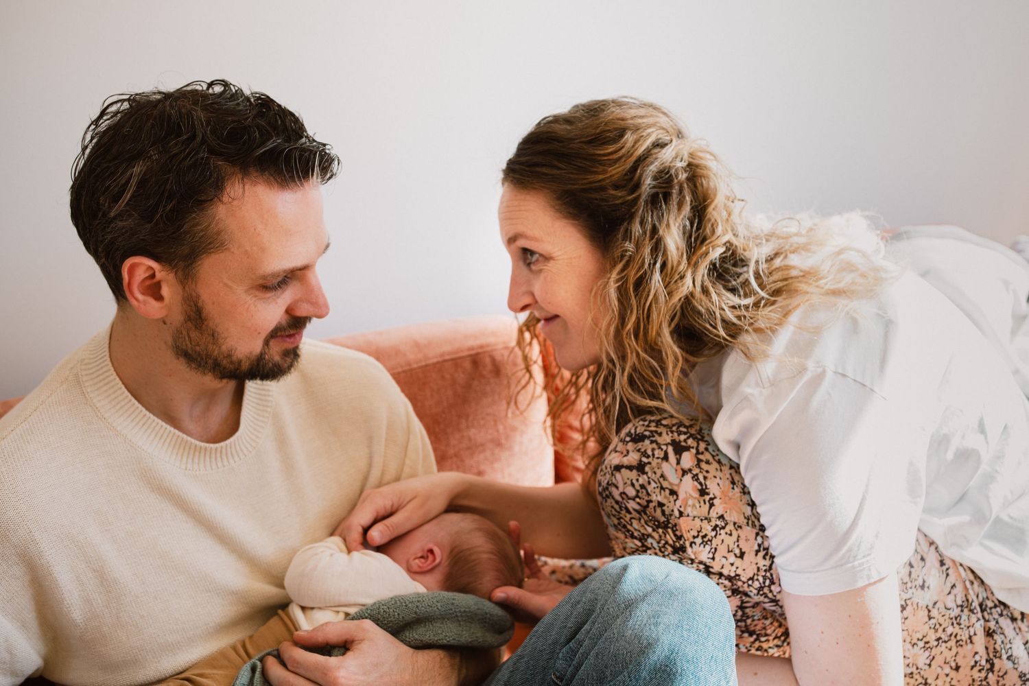 Ouders en baby tijdens intiem contactmoment op de bank, kraamtijdreportage Den Haag door Mama Nora Fotografie