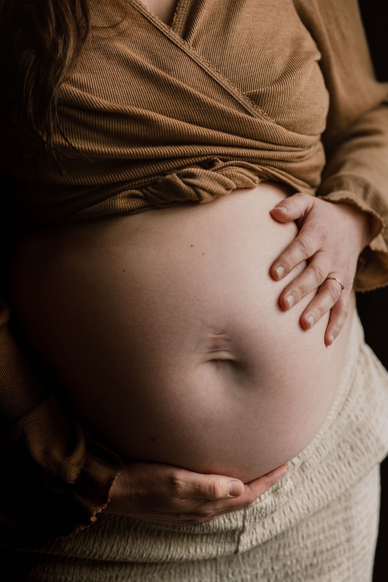 Zachte zwangerschapsreportage Bollenstreek door fotograaf Mama Nora: handen op buik.