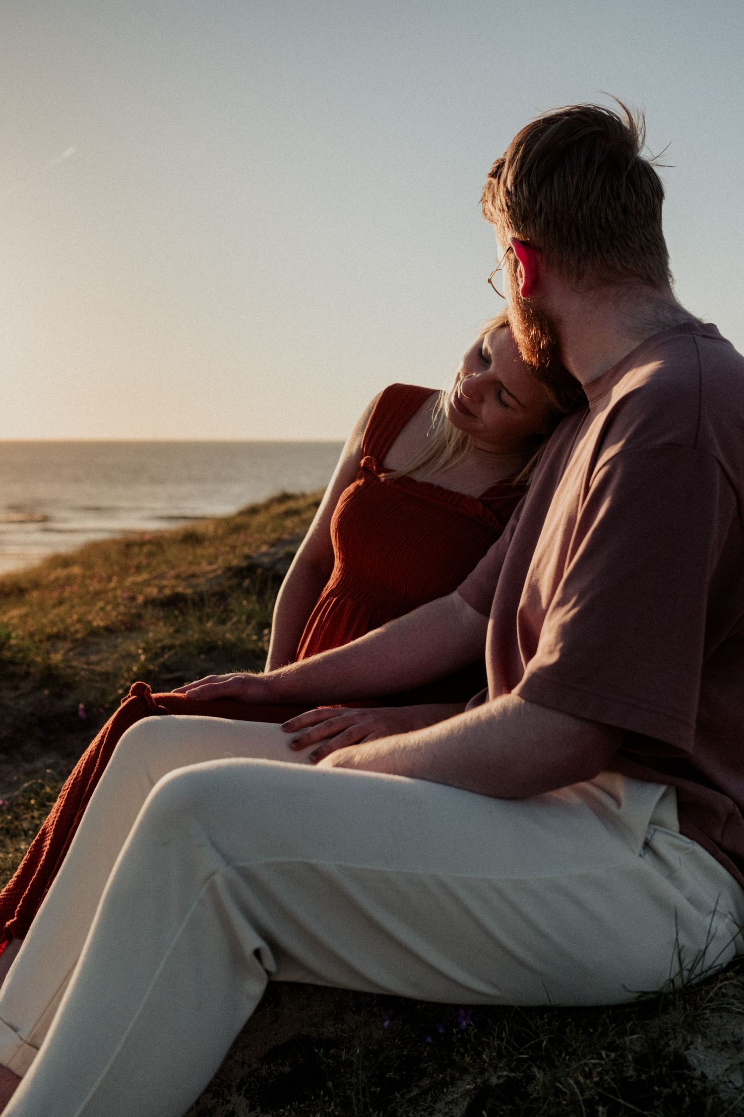 Aanstaande ouders samen aan kust buiten bij zonsondergang, documentaire zwangerschapsfotografie Leiden en Den Haag door Mama Nora Fotografie