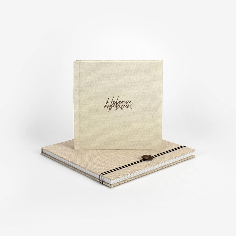 Elegant cream linen photo album with personalized Helena script embossing, displayed with matching keepsake box and ribbon closure.