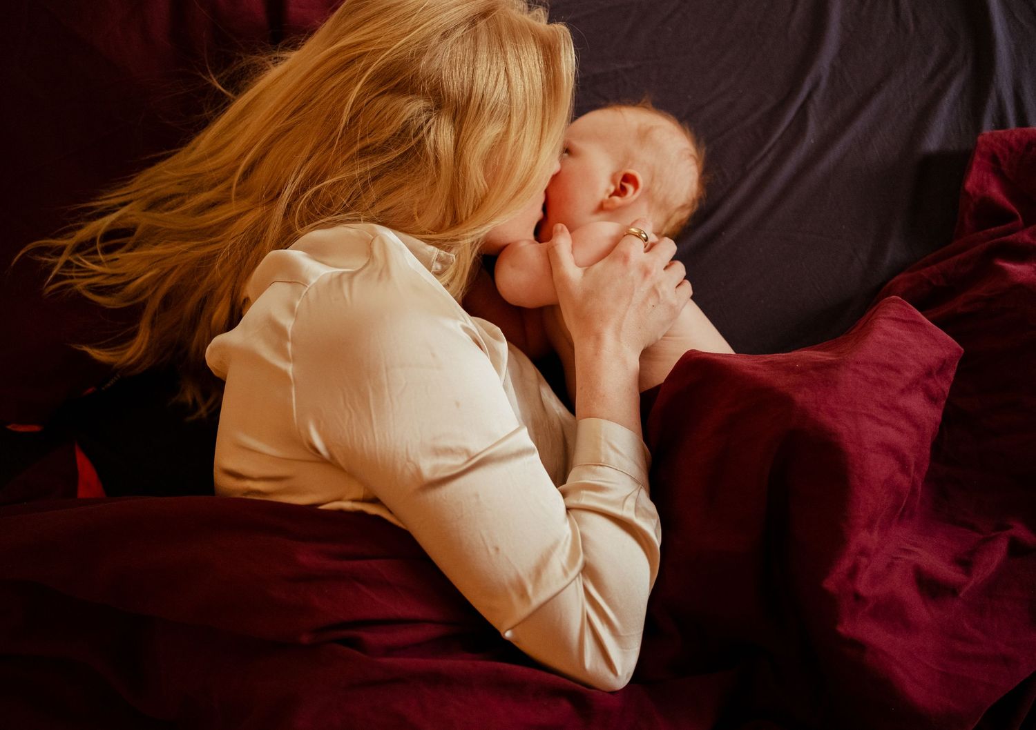 Mama en baby in bed tijdens de kraamtijd, documentaire kraamtijdfotograaf Den Haag
