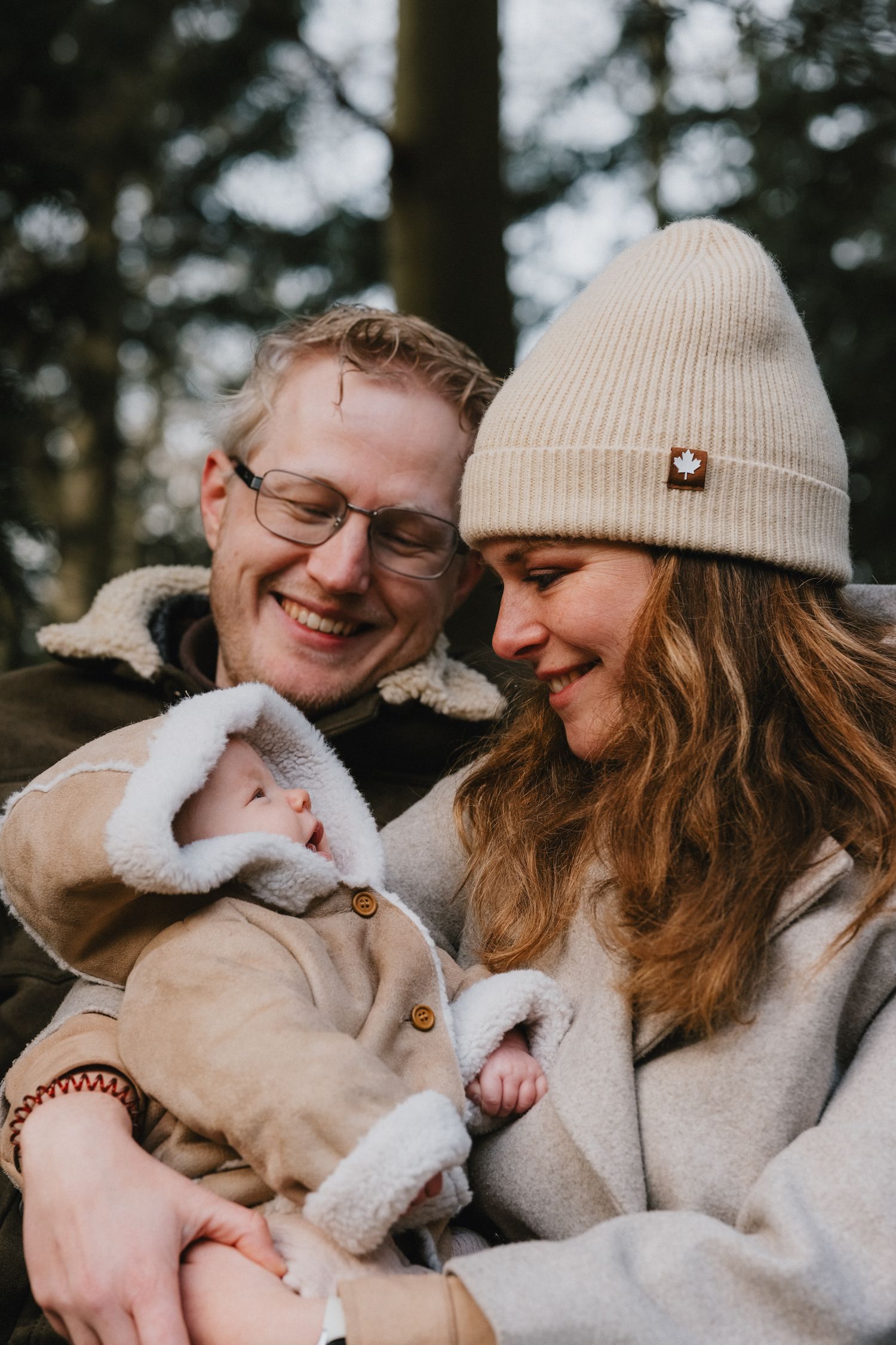 Koppel zit met hun pasgeboren baby op een bankje in de natuur nabij Leiden voor een documentaire fotoreportage.