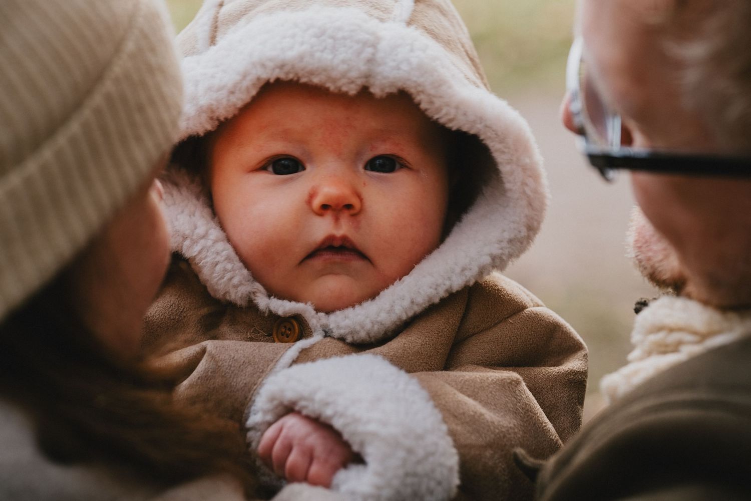 Portret van een baby die in de camera kijkt tijdens een ontspannen babyfotoshoot buiten in de regio Leiden.