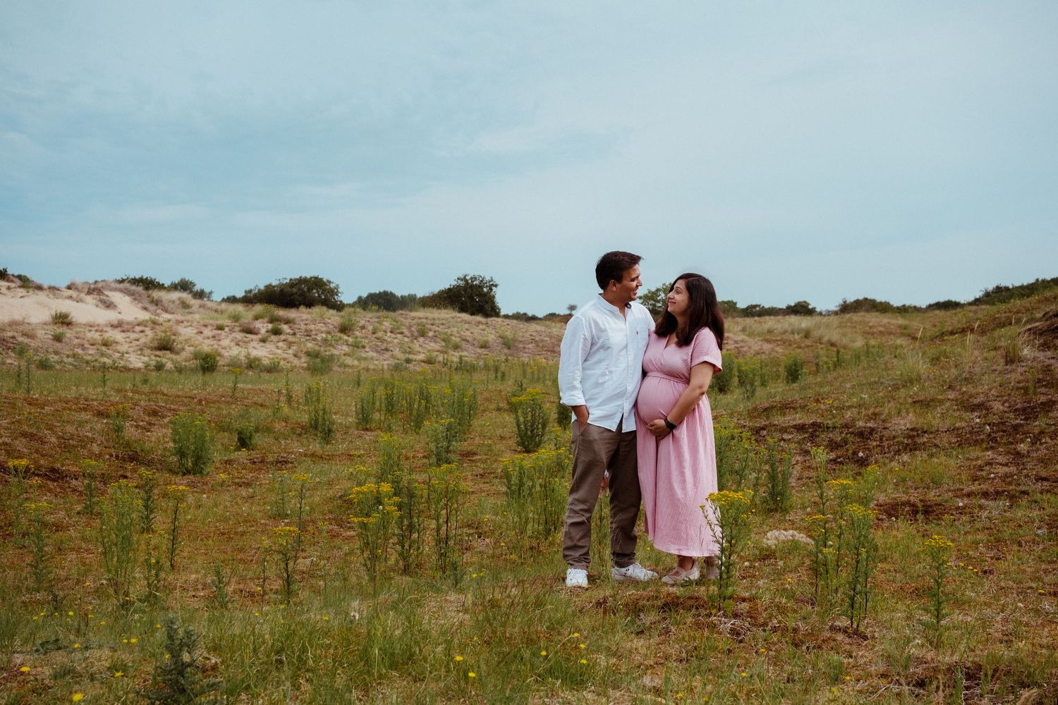 Zwangere vrouw met partner in waterleidingduinen, zwangerschapsshoot buiten regio Leiden