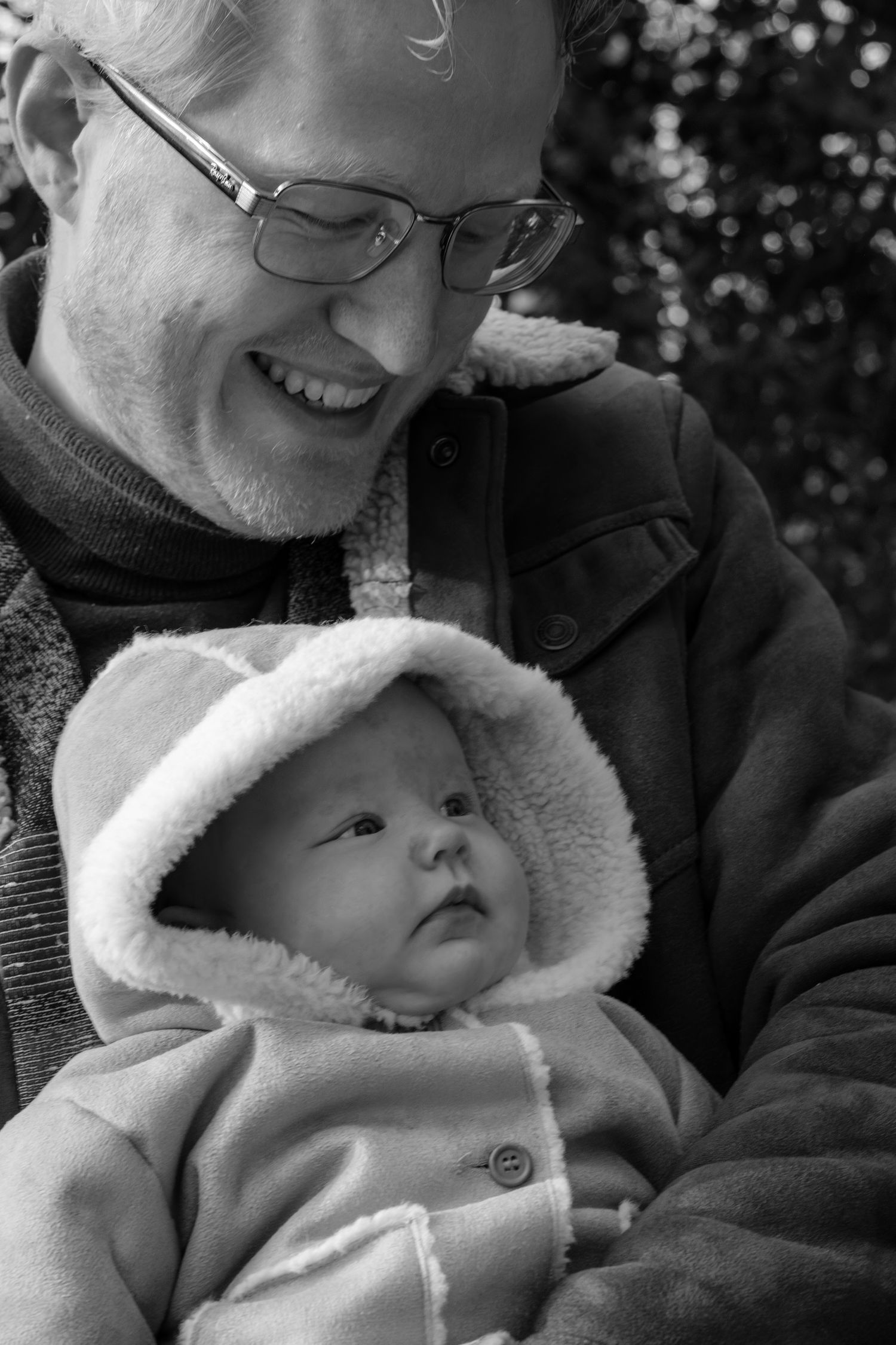 Vader knuffelt zijn pasgeboren baby tijdens een newborn reportage op een koud landgoed nabij Leiden.