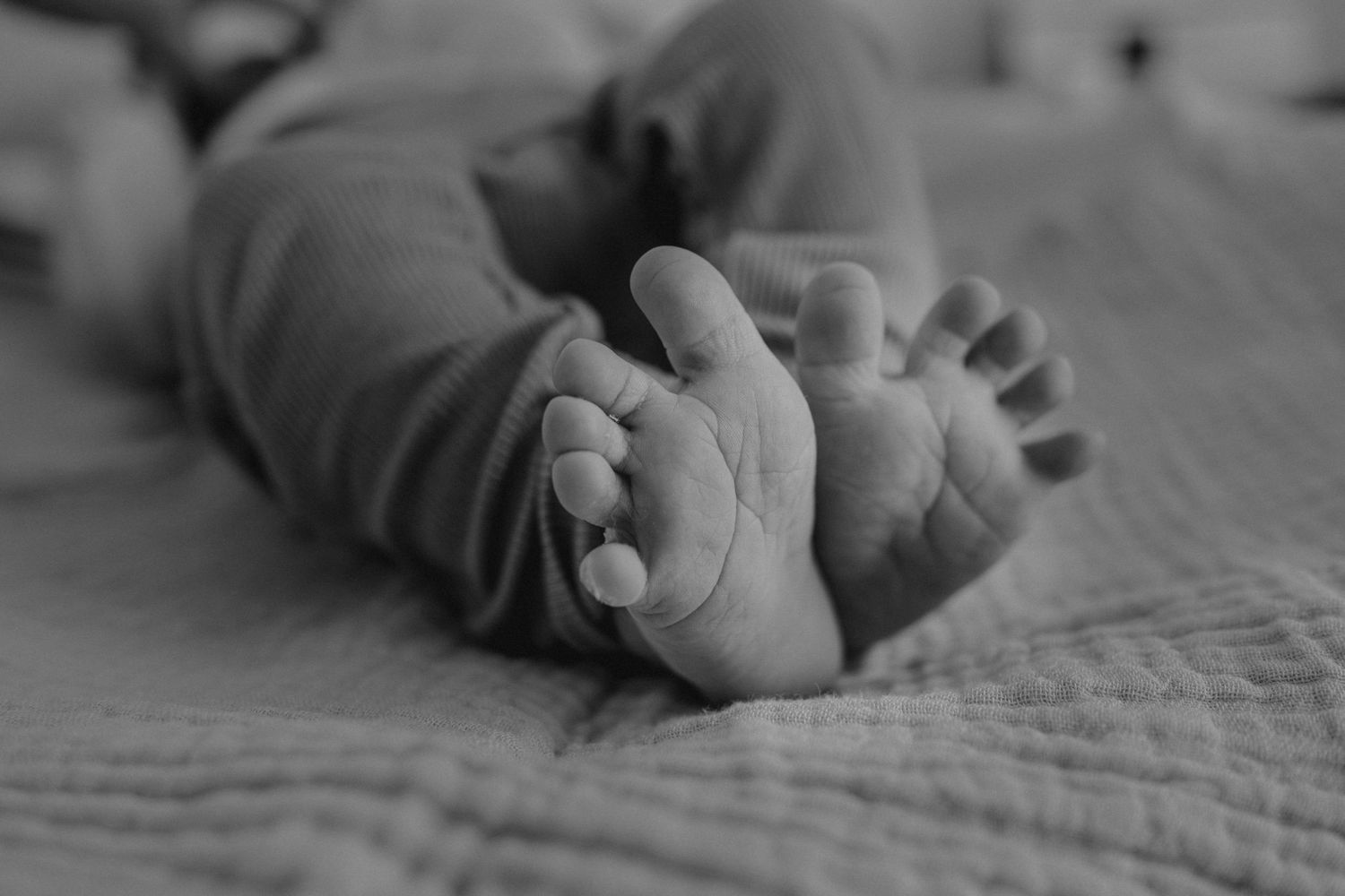 Detail van babyvoetjes in zwart-wit tijdens de kraamtijd, kraamtijdreportage Den Haag