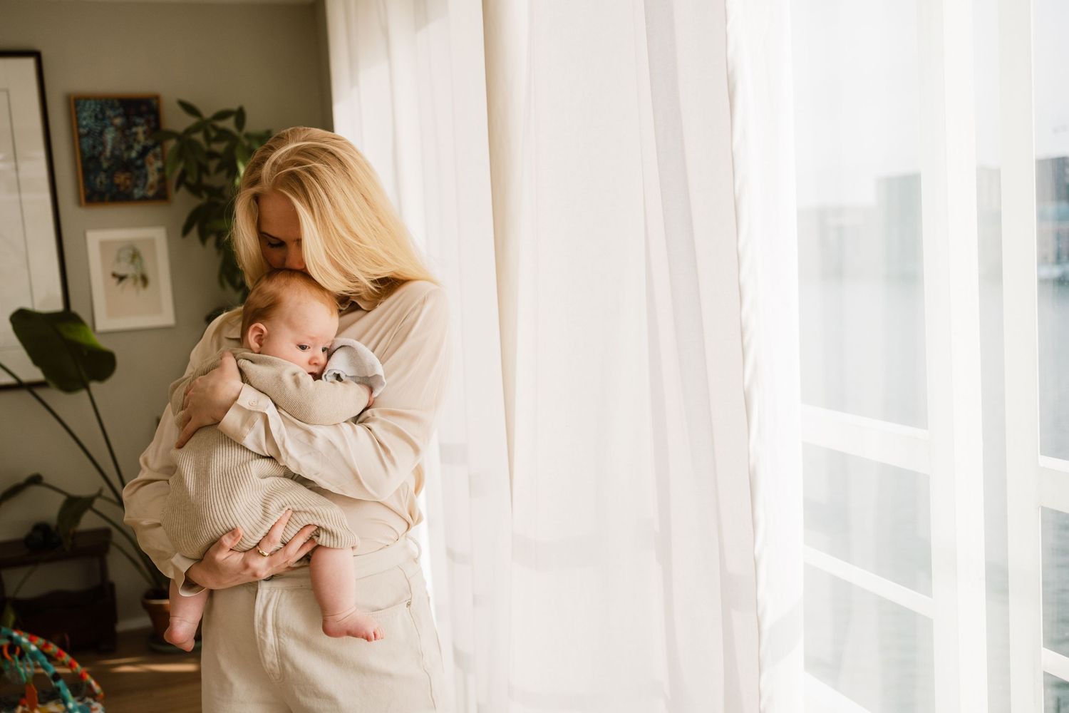 Nieuwe moeder houdt pasgeboren baby vast in de kraamtijd, documentaire kraamtijdfotografie regio Rotterdam en Warmond
